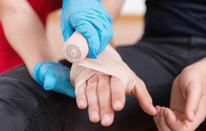 Hand Placing Bandage - First Aid in Mackay, QLD
