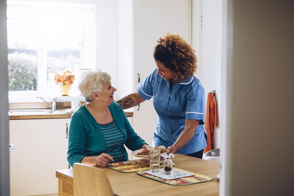 Care Worker Giving an Old Lady Her Dinner in Her Home - First Aid in Mackay, QLD