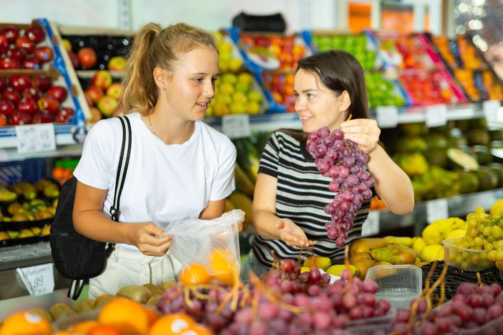 Two young women shopping for fruit at the supermarket - First Aid in Mackay, QLD
