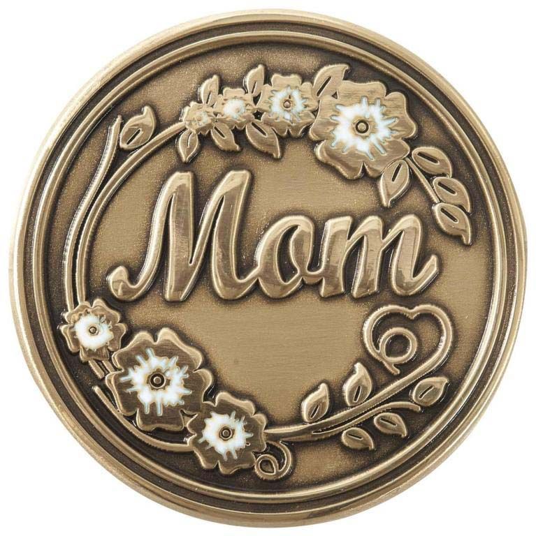 A bronze coin with the word mom surrounded by flowers and leaves.