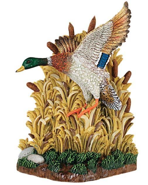 A statue of a duck flying over a pile of tall grass