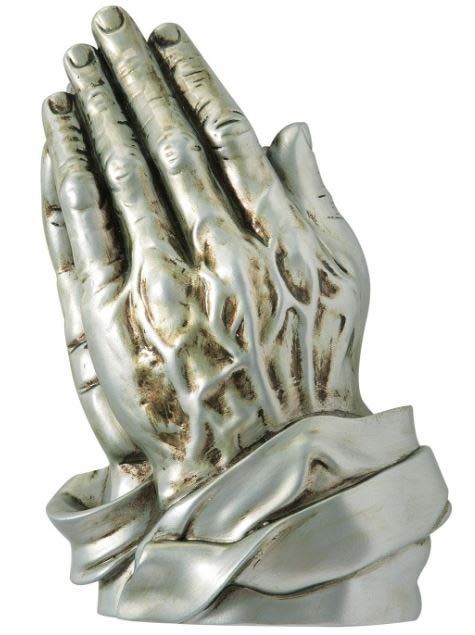 A silver statue of praying hands on a white background