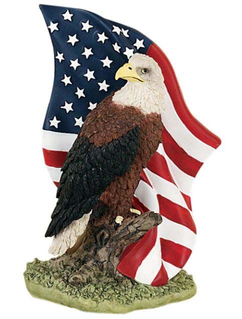 A bald eagle statue with an american flag behind it