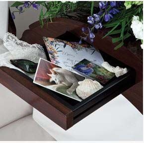 A wooden tray with seashells and flowers on it