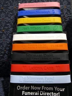 A stack of bracelets that say order now from your funeral director