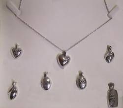 A necklace and pendants are displayed on a white surface.