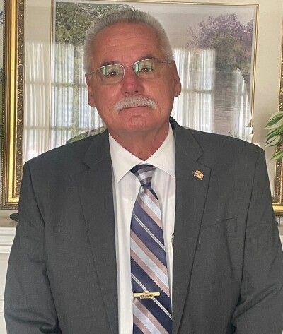 A man in a black shirt is standing in a circle with his hands on his hips