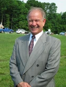 A man in a plaid shirt is standing in a circle with his hands in his pockets.