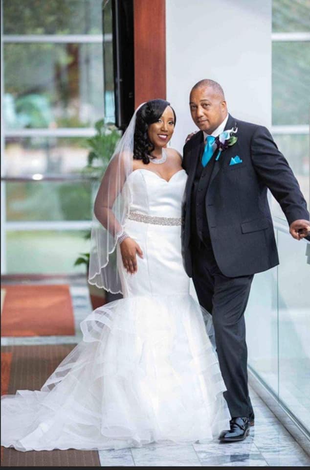 A bride and groom are posing for a picture on their wedding day.