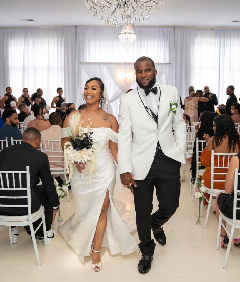 A bride and groom are walking down the aisle at their wedding holding hands.