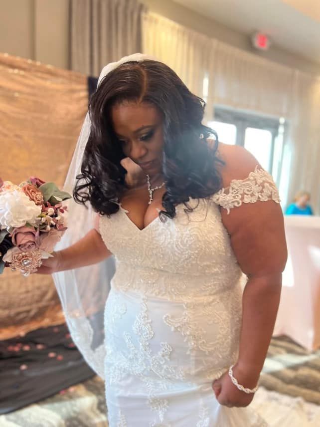 A woman in a wedding dress is holding a bouquet of flowers.