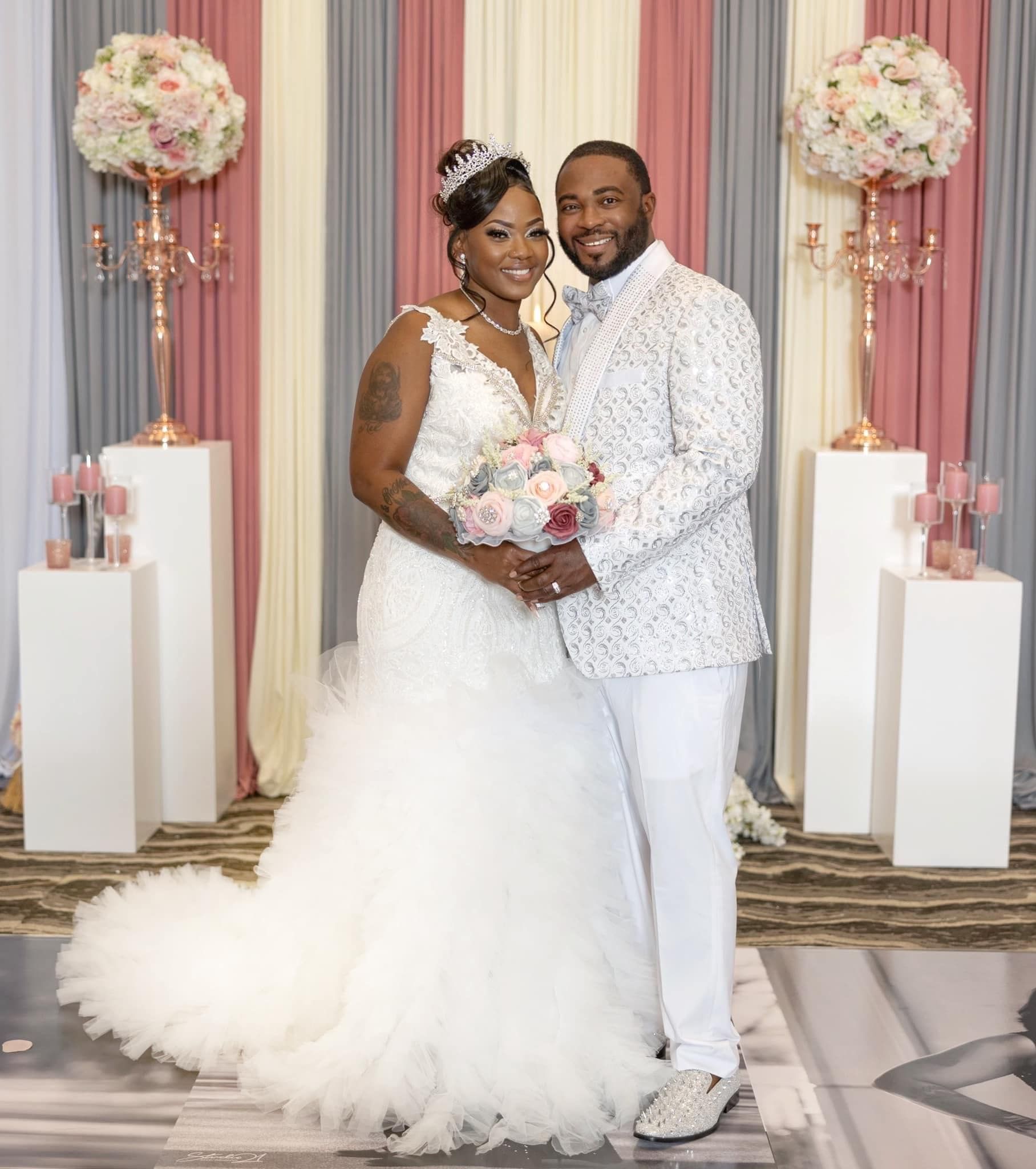 A bride and groom are posing for a picture at their wedding.
