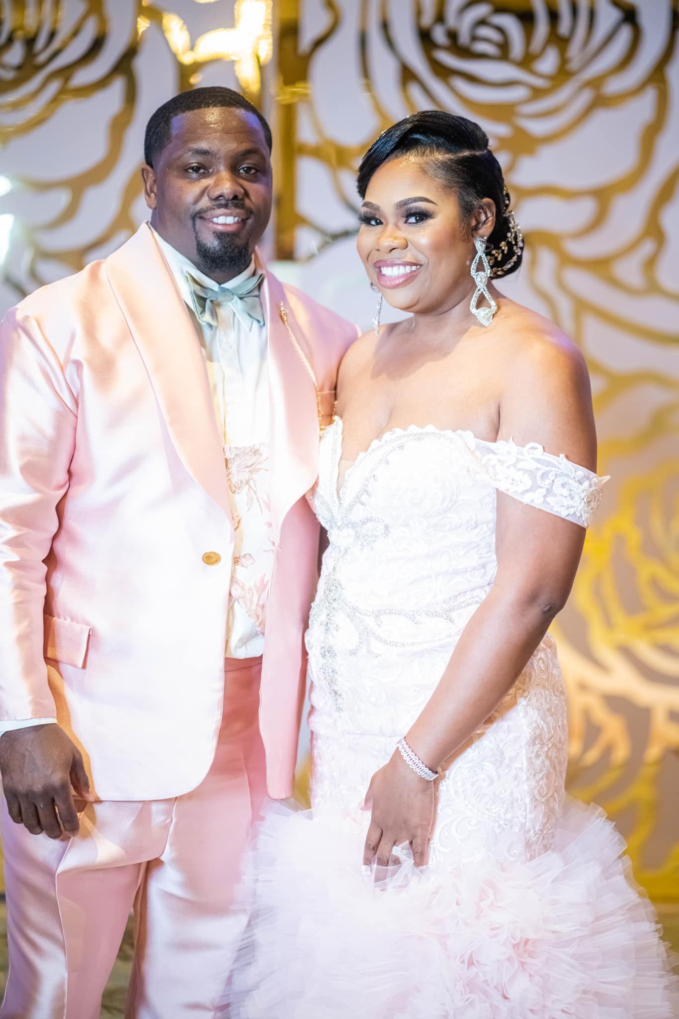 A bride and groom are posing for a picture at their wedding reception.