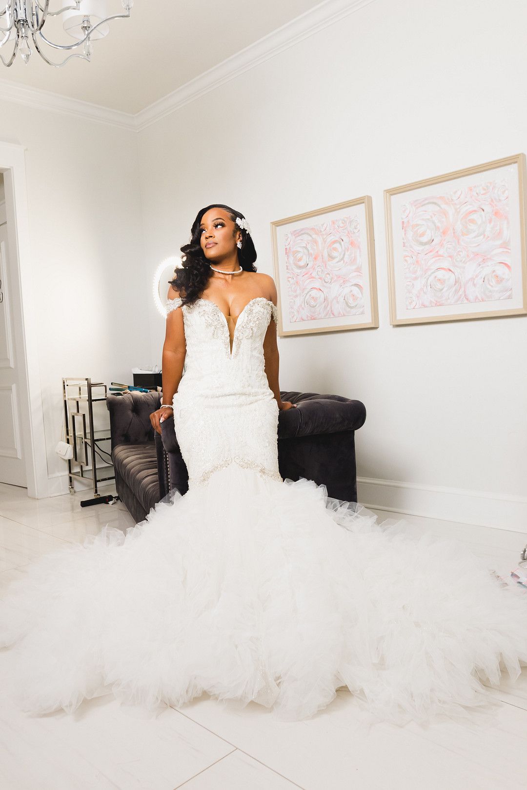 A woman in a white wedding dress is standing in a room.