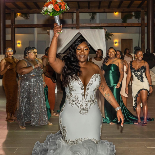 A woman in a white dress is holding a bouquet of flowers.