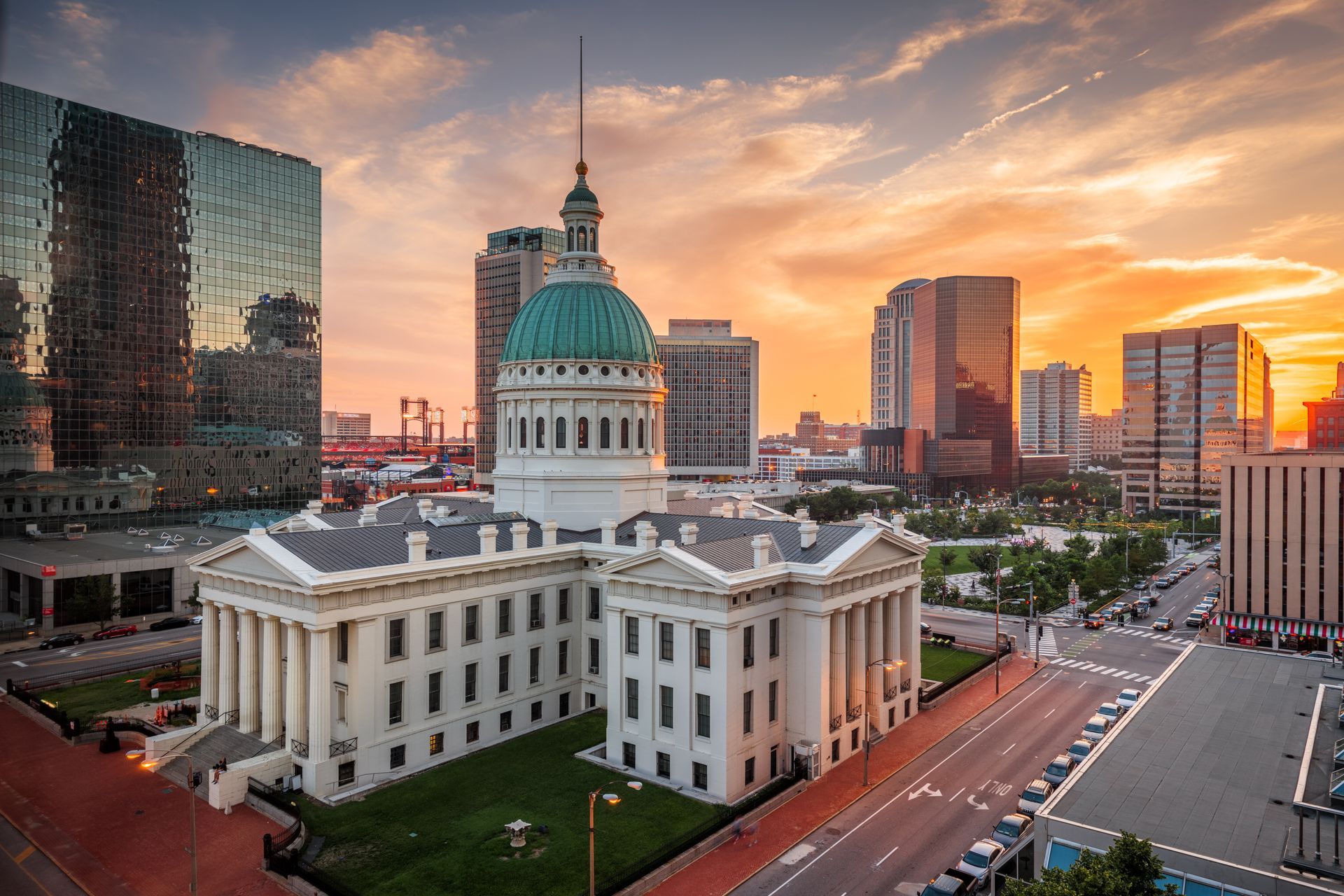 St. Louis City Hall with green dome, office buildings at sunset.