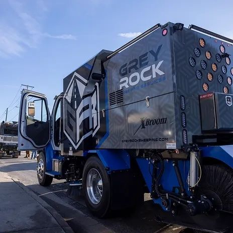 A grey rock truck is parked on the side of the road