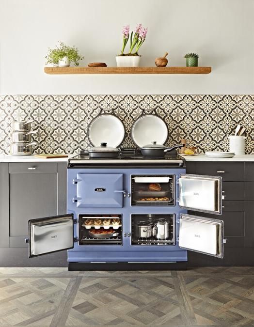 Did you know, today's AGAs consume less energy than ever before? Photograph of Blue AGA eR3-100 Cast Iron Range Cooker, installed in a modern kitchen with oven doors open.