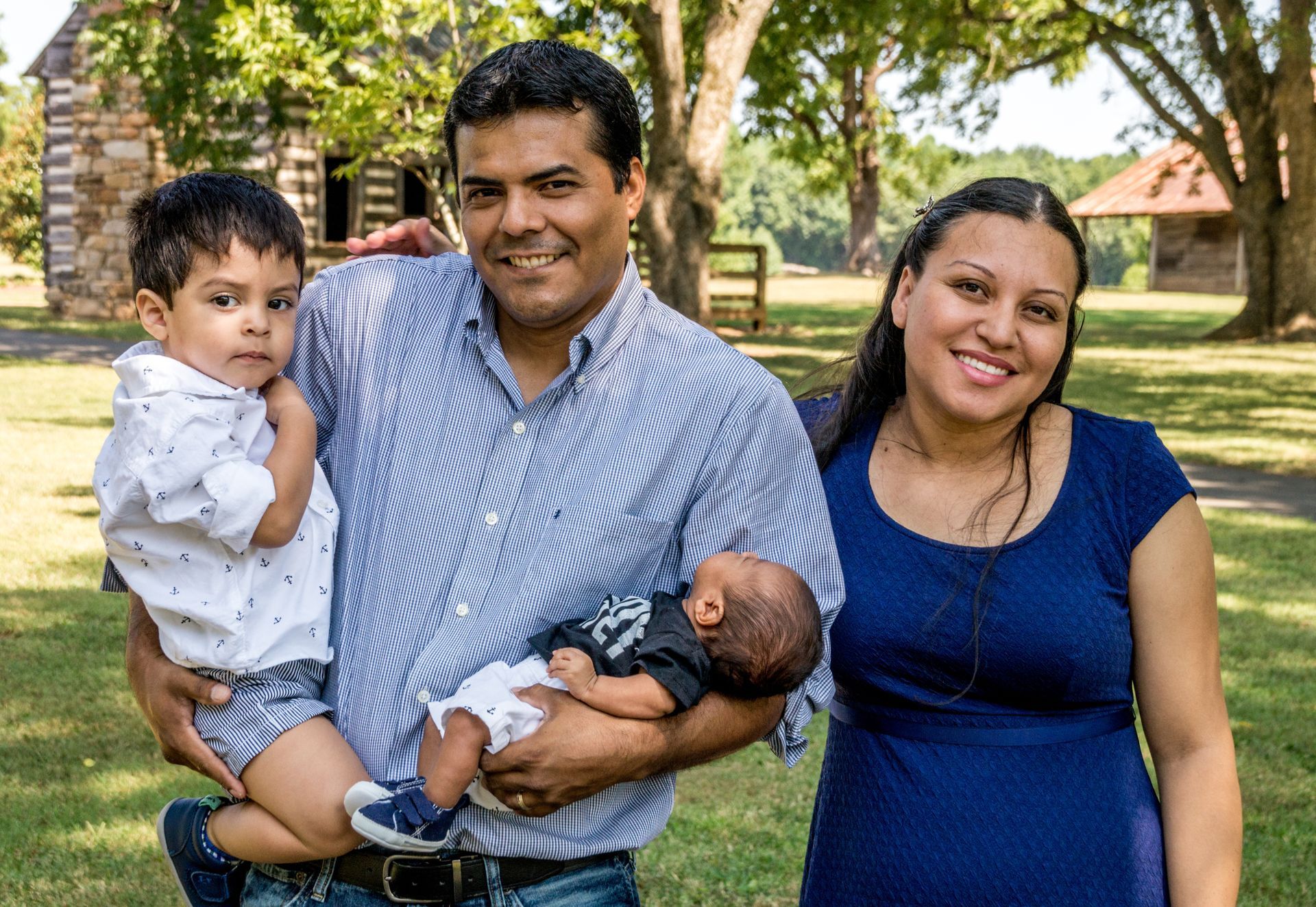 A family is posing for a picture in a park.