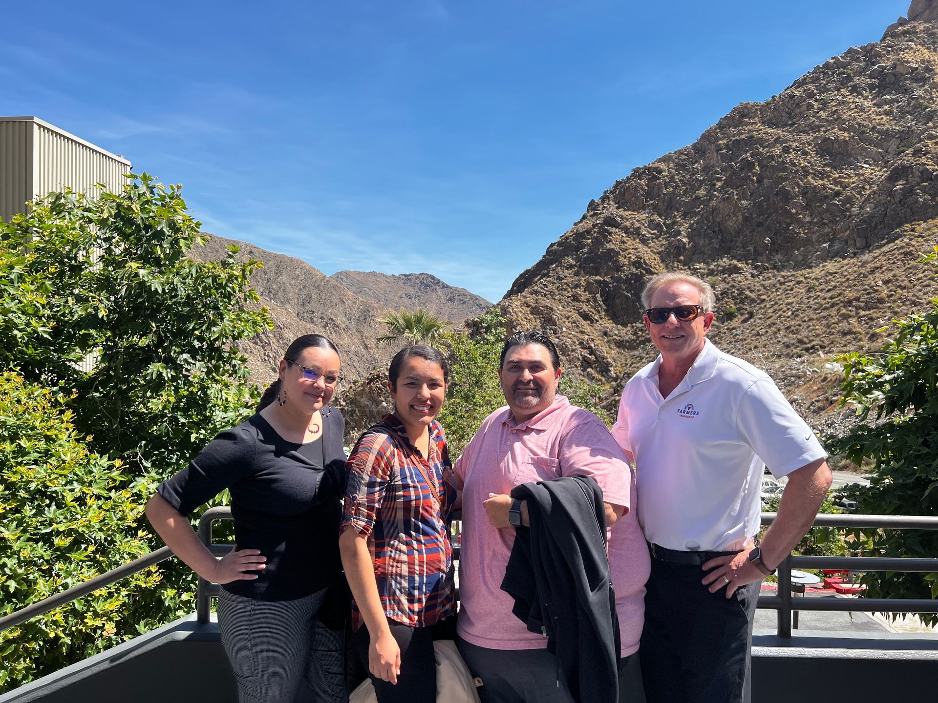 The agents of Breitfeller Insurance Agency are posing for a picture in front of a mountain.