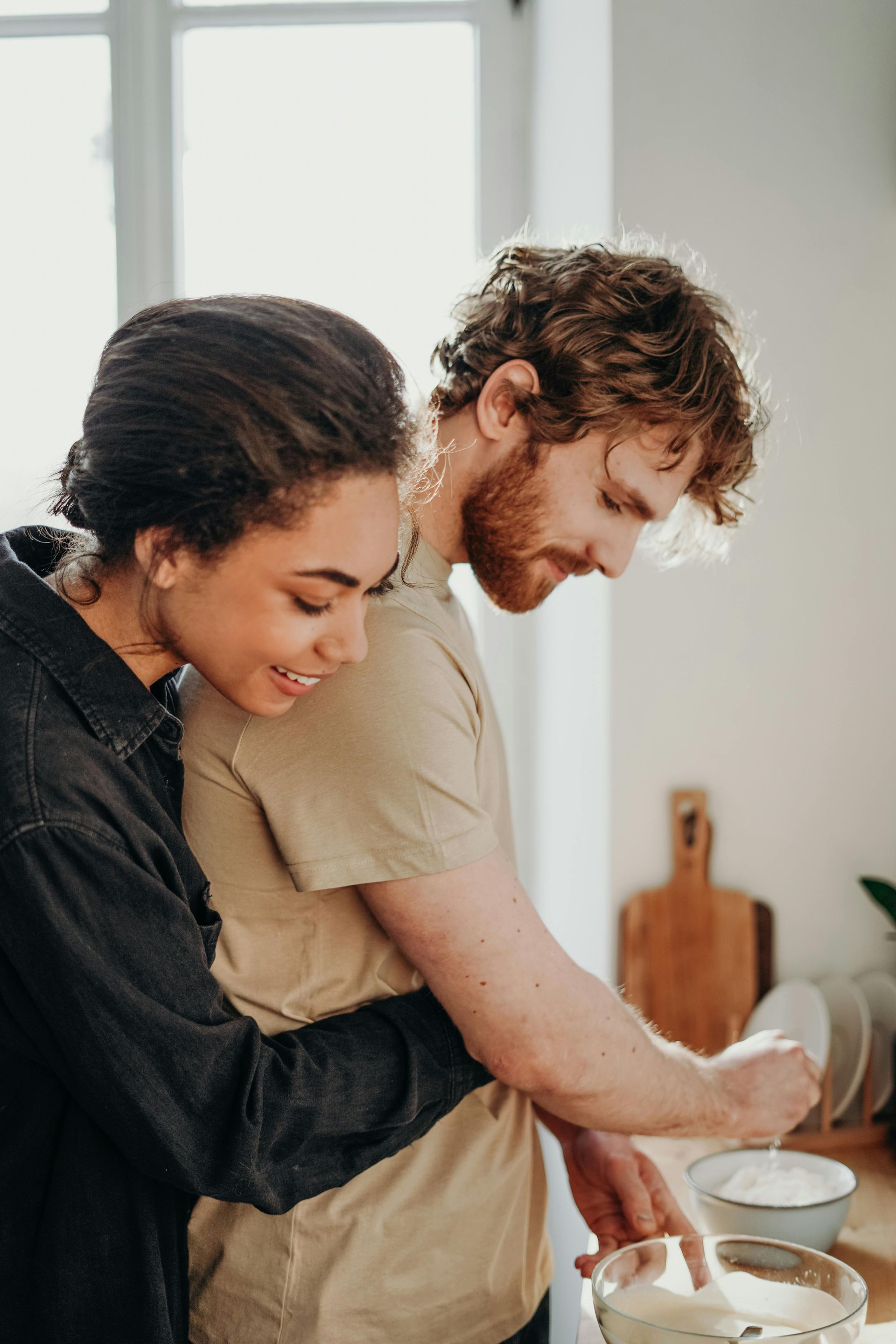 A man and a woman are cooking together in a kitchen.