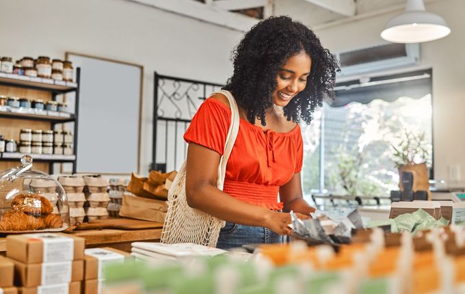 A woman is standing at a counter in a bakery.