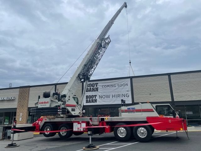 A large crane lifting a sign for a 