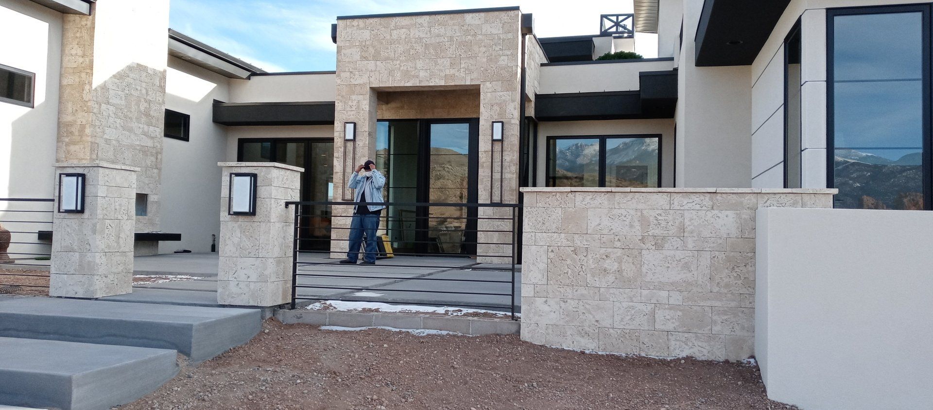 A man is standing in front of a large house.