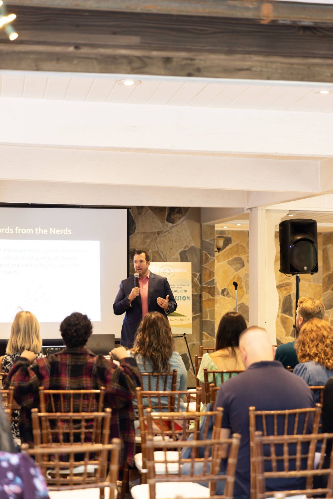 A man is giving a presentation to a group of people sitting in chairs.