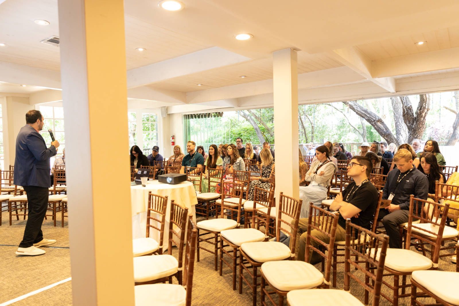 A man is giving a presentation to a group of people sitting in chairs.
