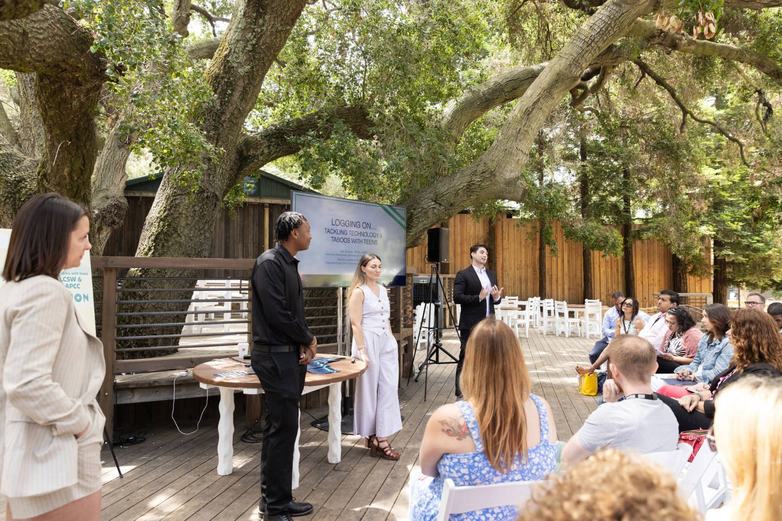 A man is giving a presentation to a group of people sitting in chairs.