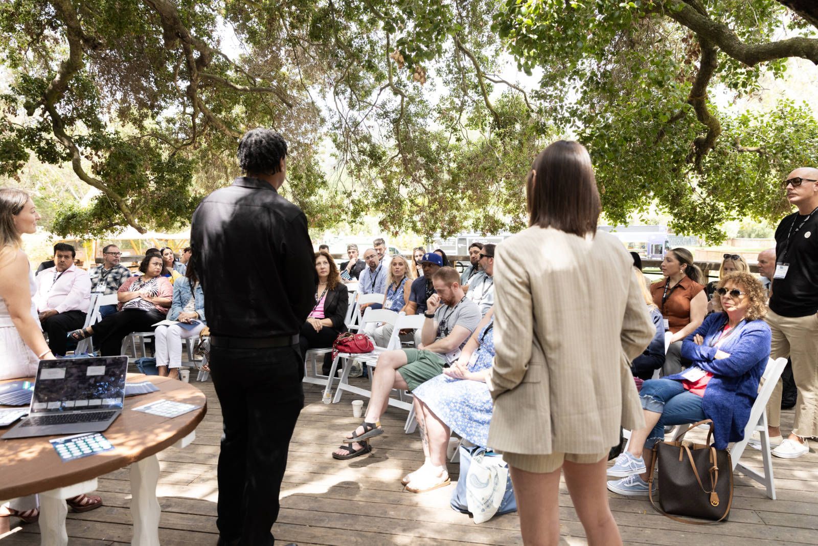 A group of people are standing around a table in a park.