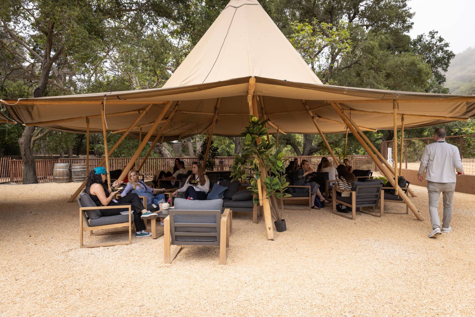A group of people are sitting under a tent.