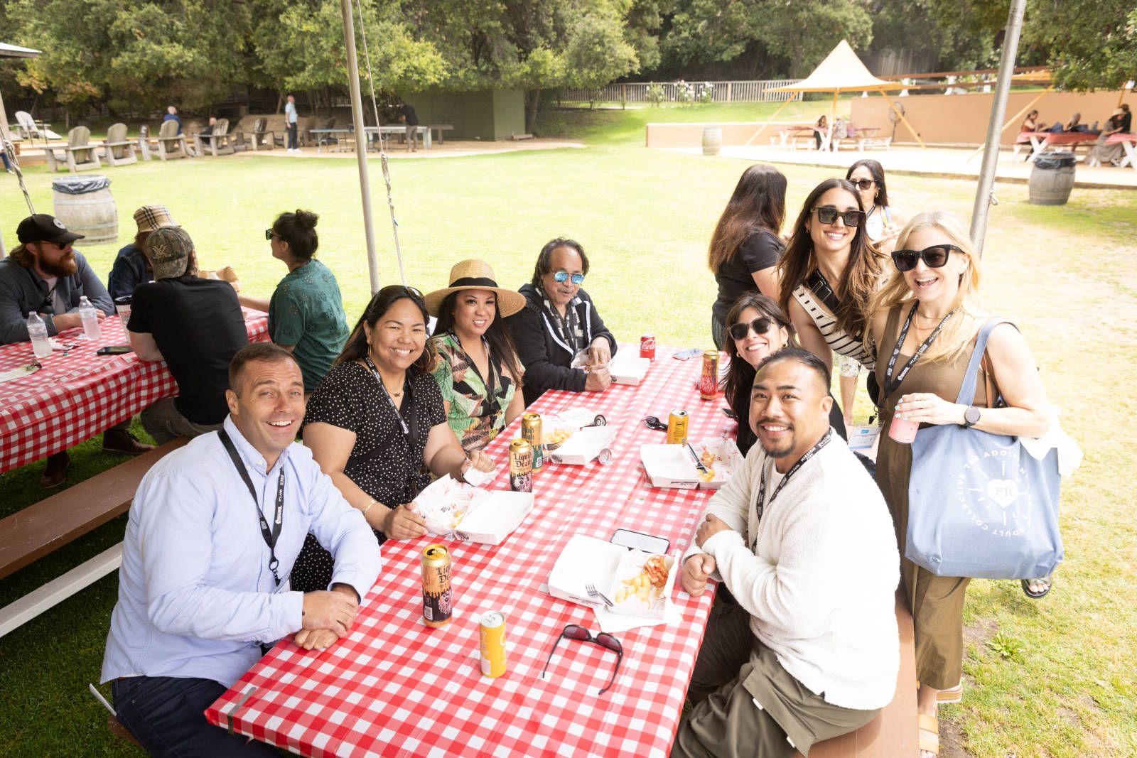 A group of people are sitting at a picnic table in a park.