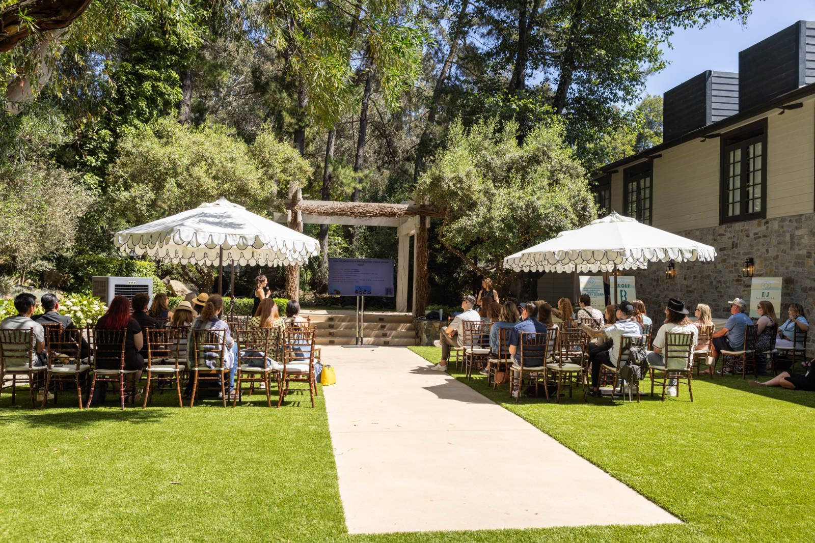 A group of people are sitting in chairs in front of a building.
