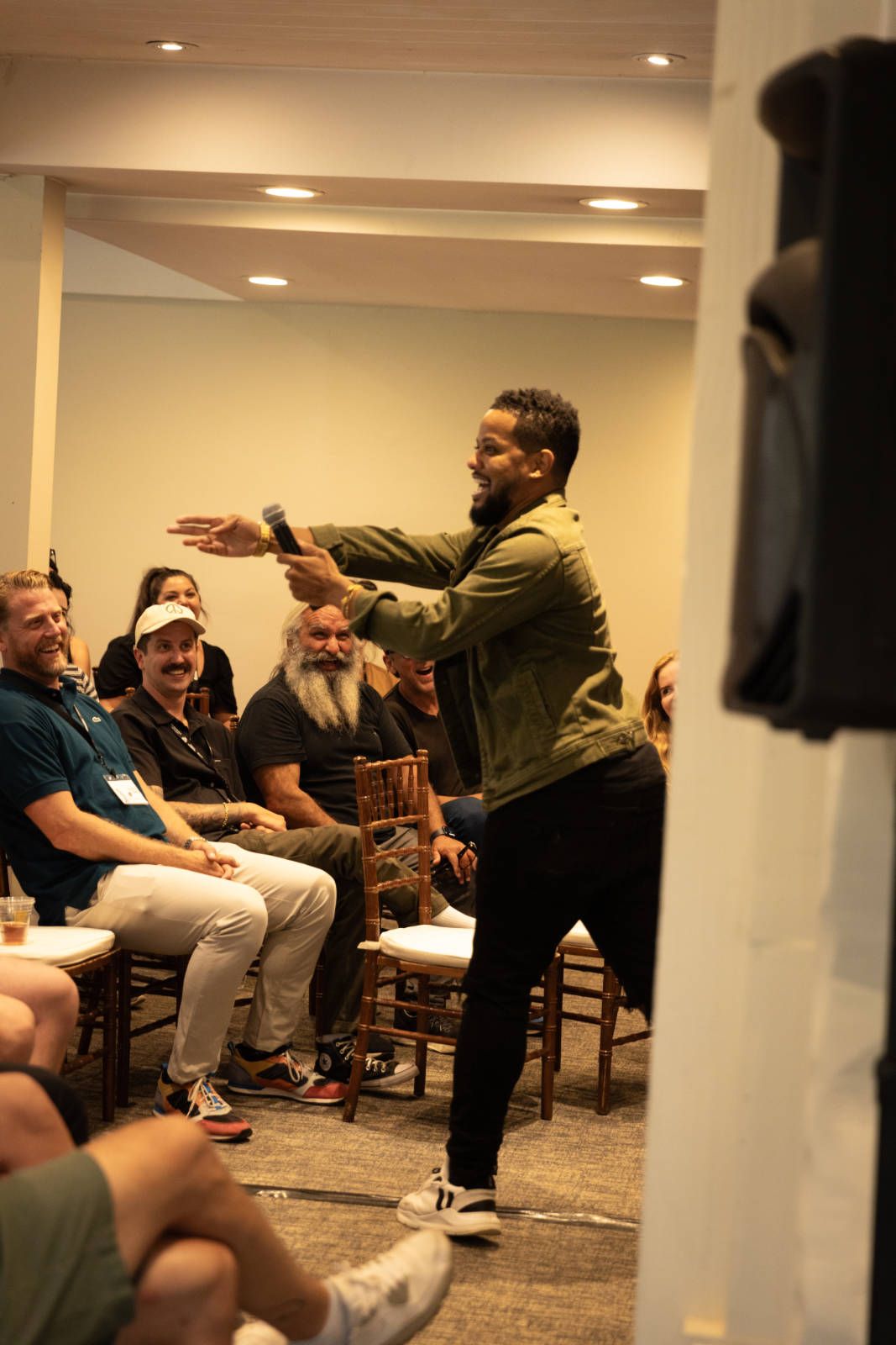 A man is standing in front of a group of people sitting in chairs.