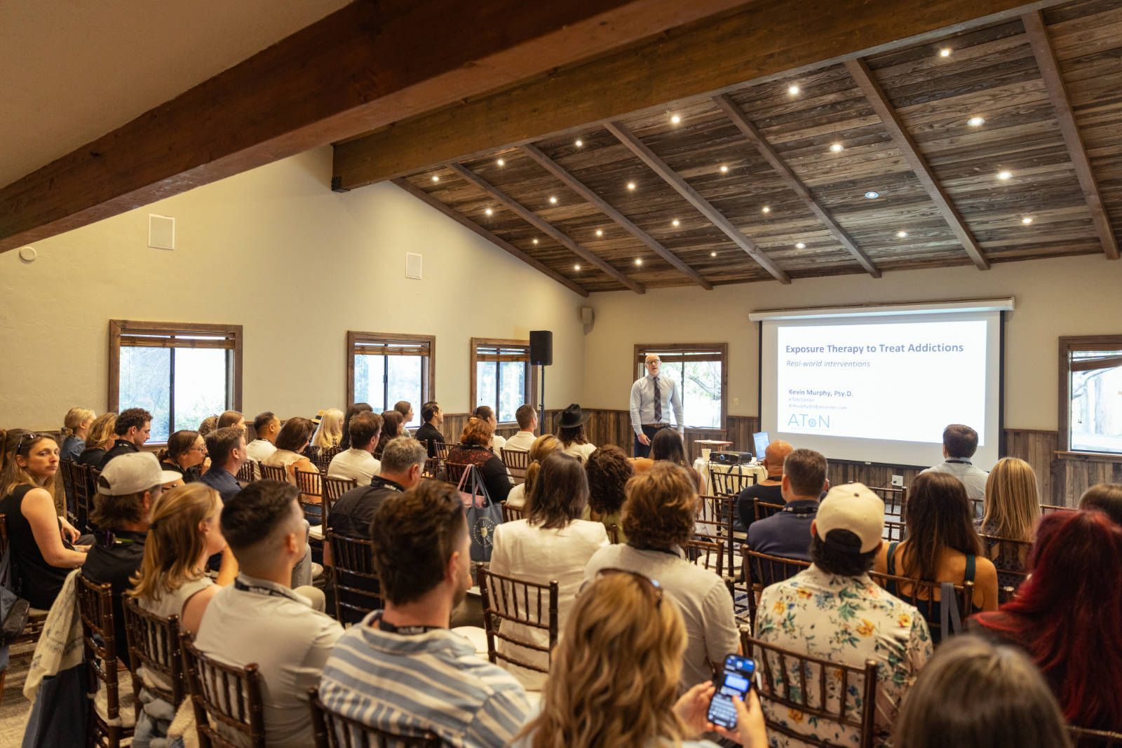 A man is giving a presentation to a large group of people in a room.