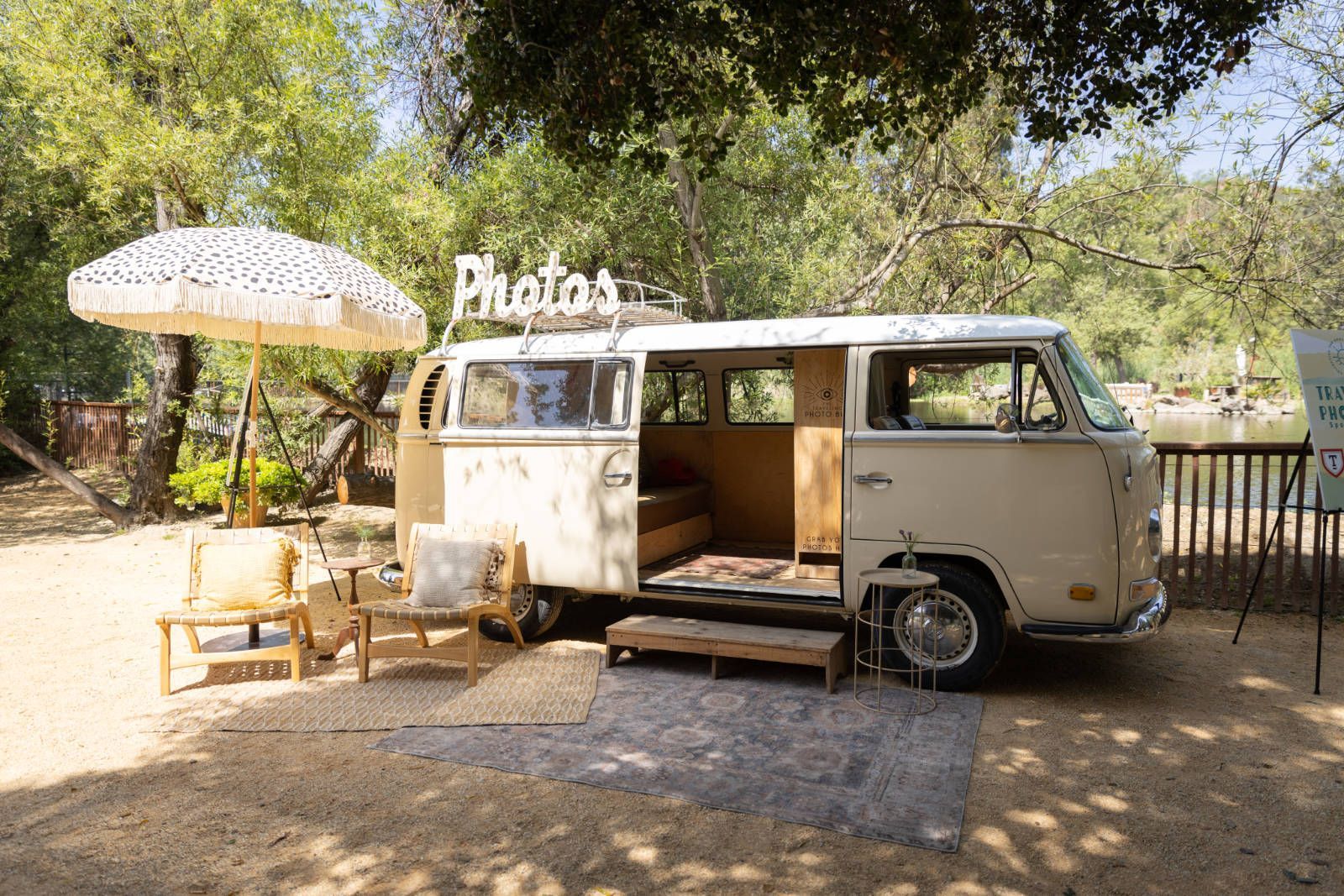 A white van is parked in a parking lot with a sign that says photos.