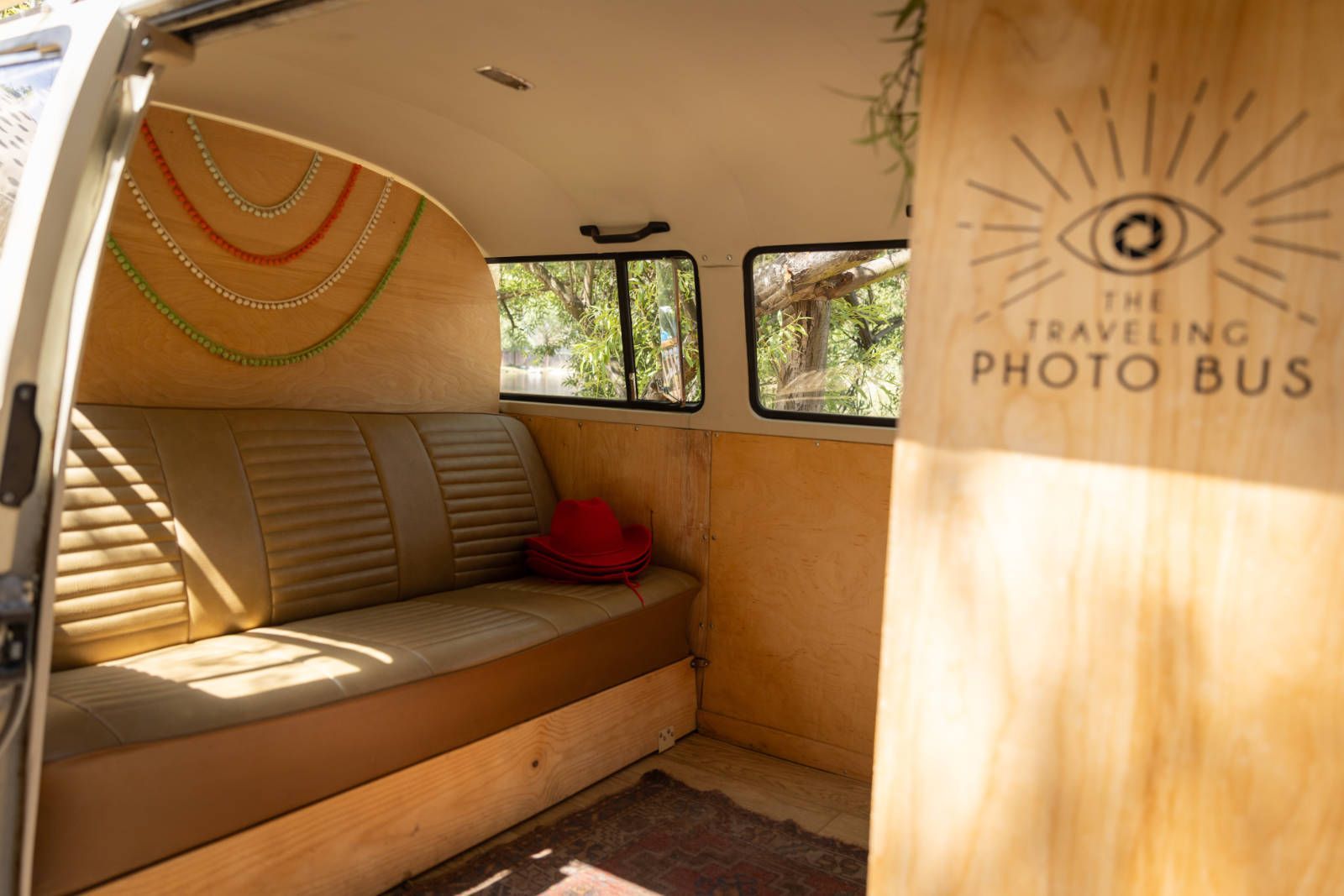 The inside of a van with a couch and a sign that says `` the traveling photo bus ''.