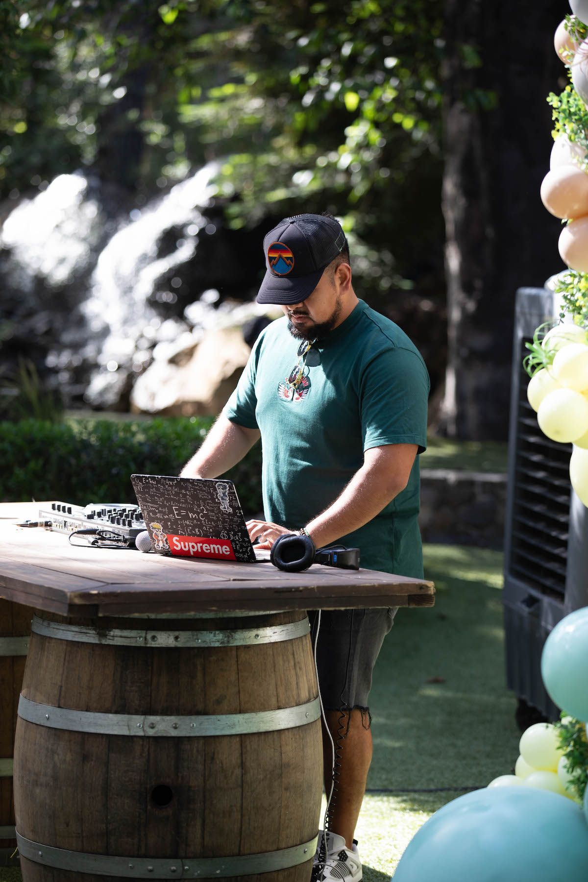 A man is standing at a table using a laptop computer.