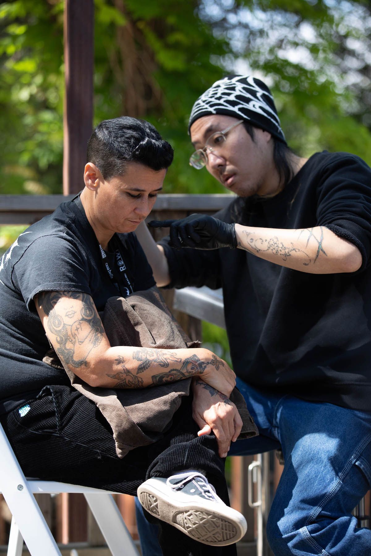A man is comforting a woman who is sitting on a chair.