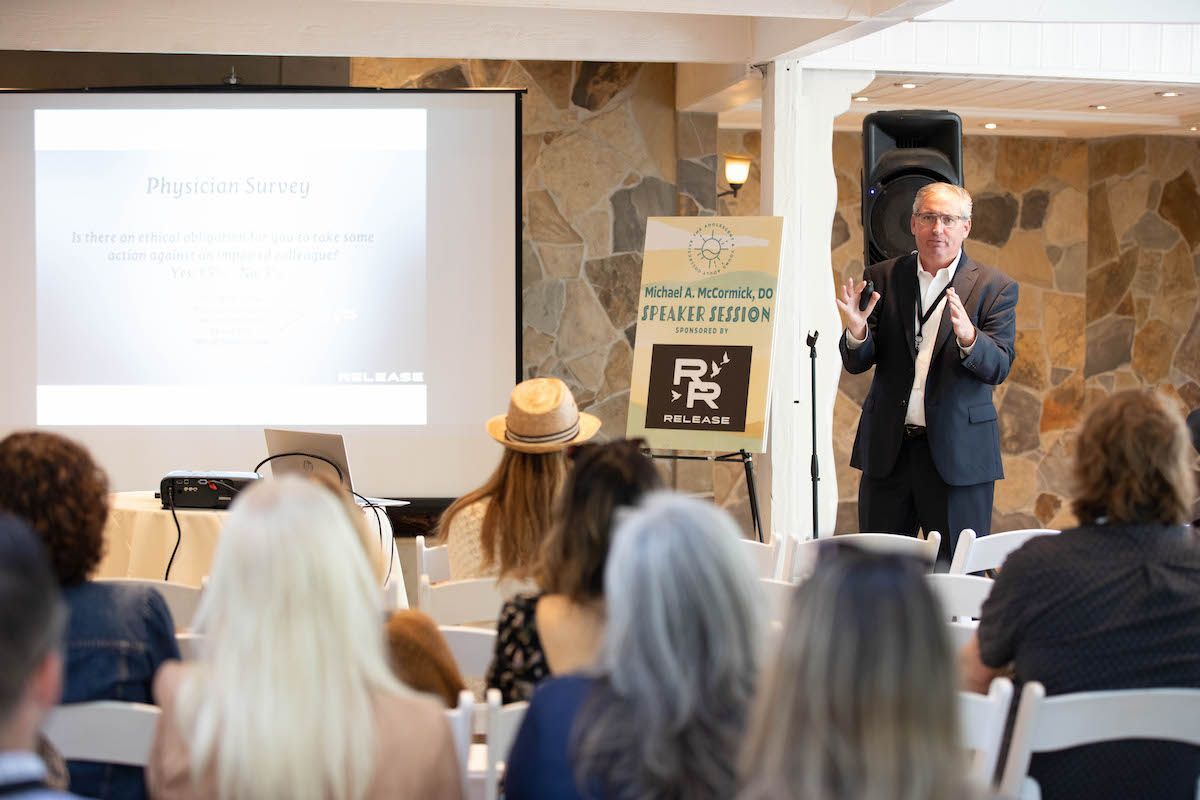 A man in a suit is giving a presentation to a group of people.