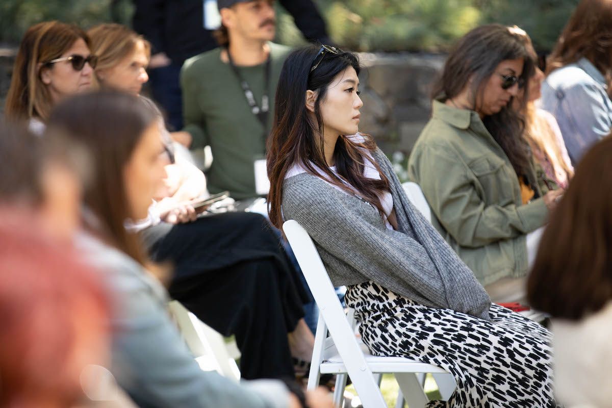 A woman is sitting in a chair in a crowd of people.