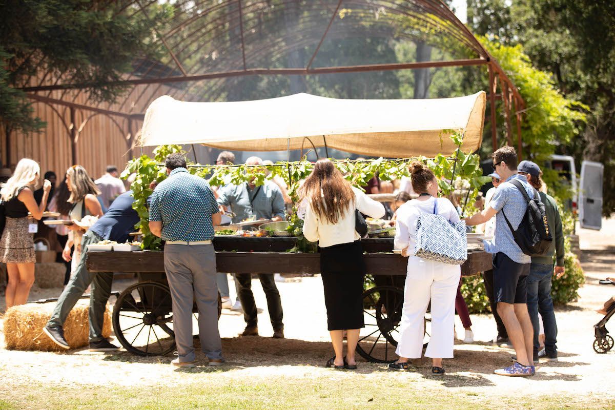 A group of people are standing around a cart.