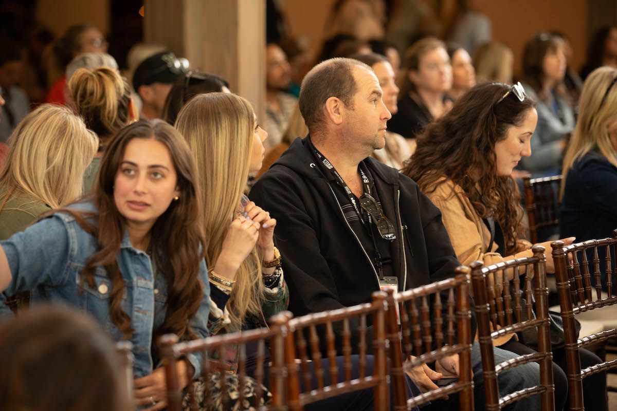 A group of people are sitting in chairs at a conference.