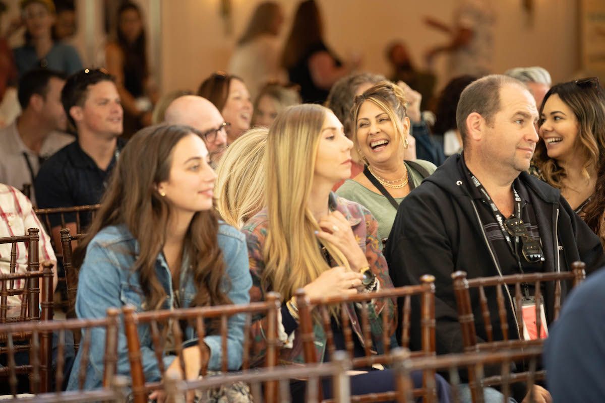 A group of people are sitting in chairs at a conference.
