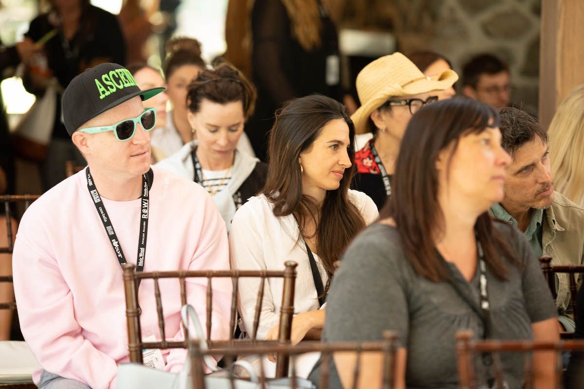 A group of people are sitting in chairs at a conference.