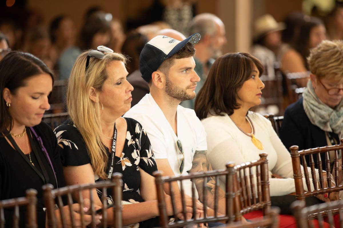 A group of people are sitting in chairs at a conference.