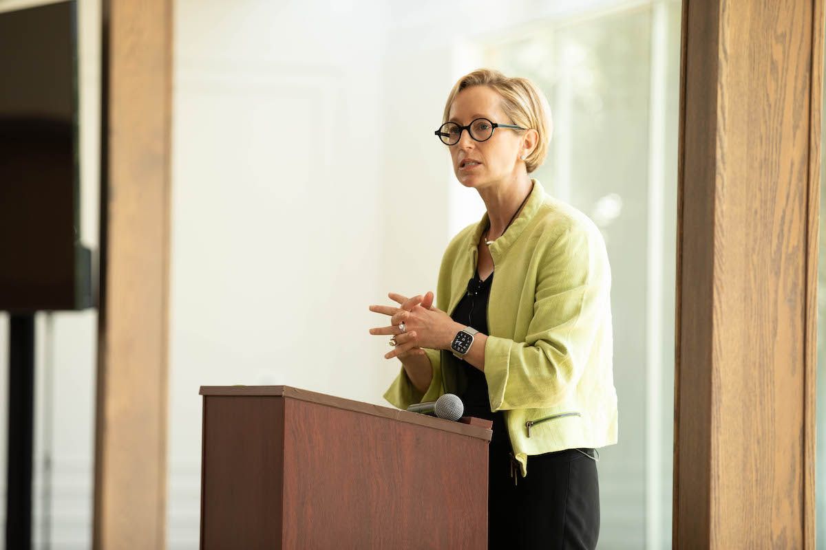 A woman is standing at a podium giving a speech.
