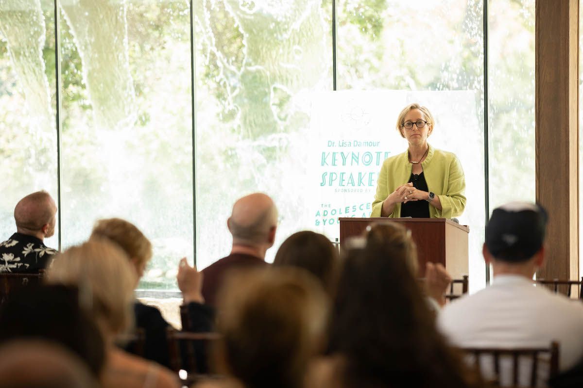 A woman is standing at a podium giving a presentation to a group of people.